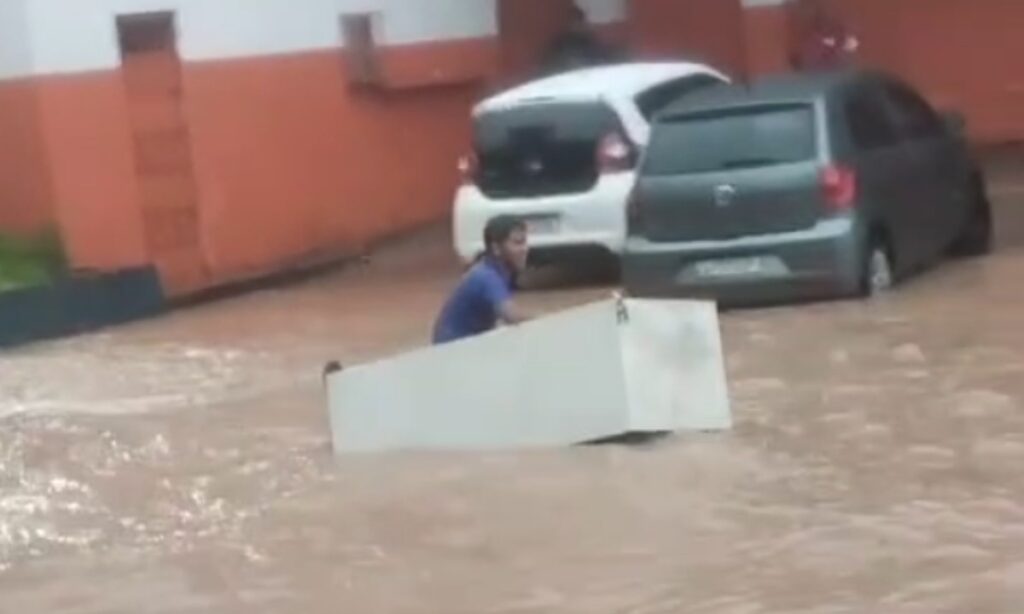 Homem Navega em Avenida Alagada Usando Geladeira Após Chuva em Manaus Homem Navega em Avenida Alagada Usando Geladeira Após Chuva em Manaus